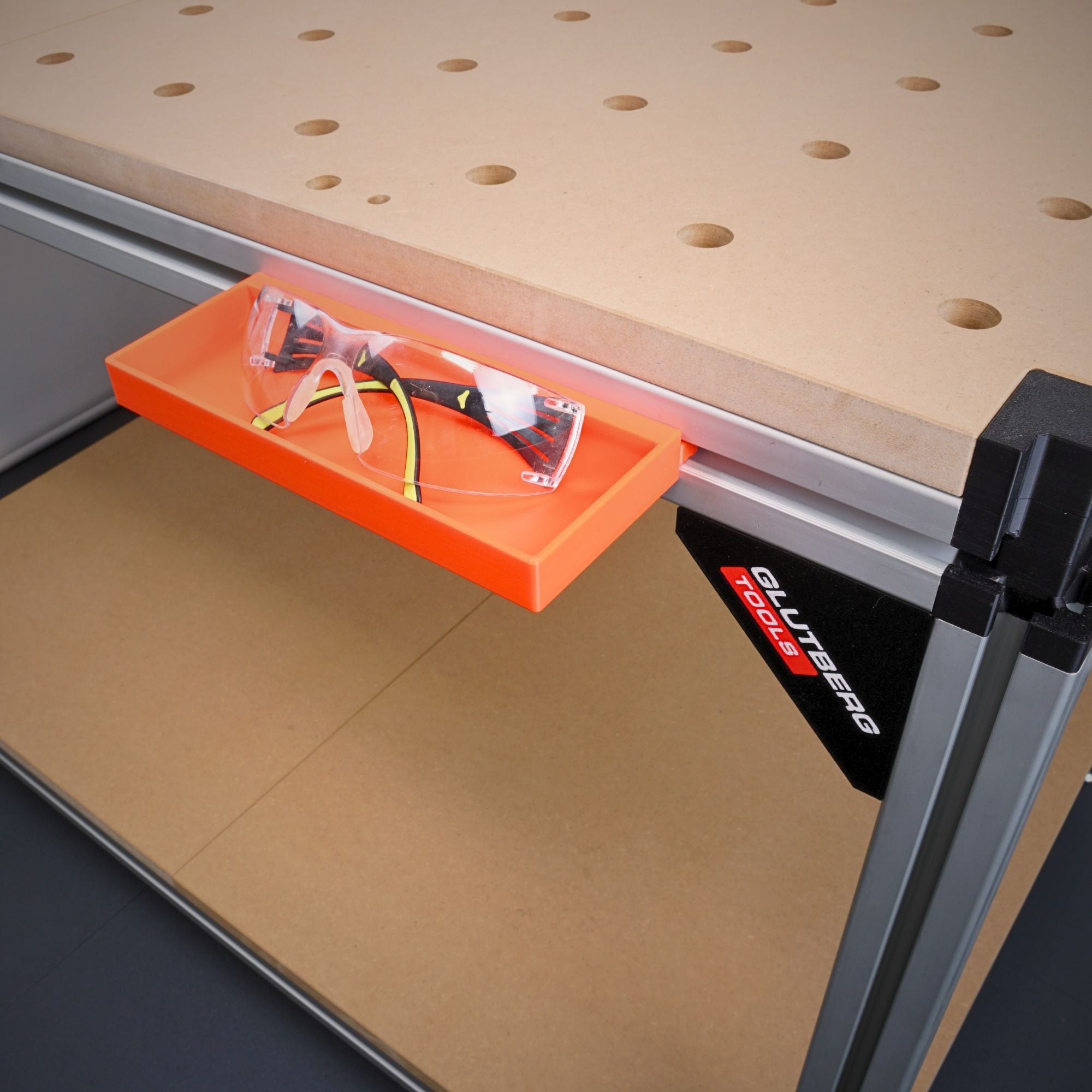 Werkzeugablage für die Workstation Pro in Orange mit Schutzbrille, an der Werkbank eingehängt