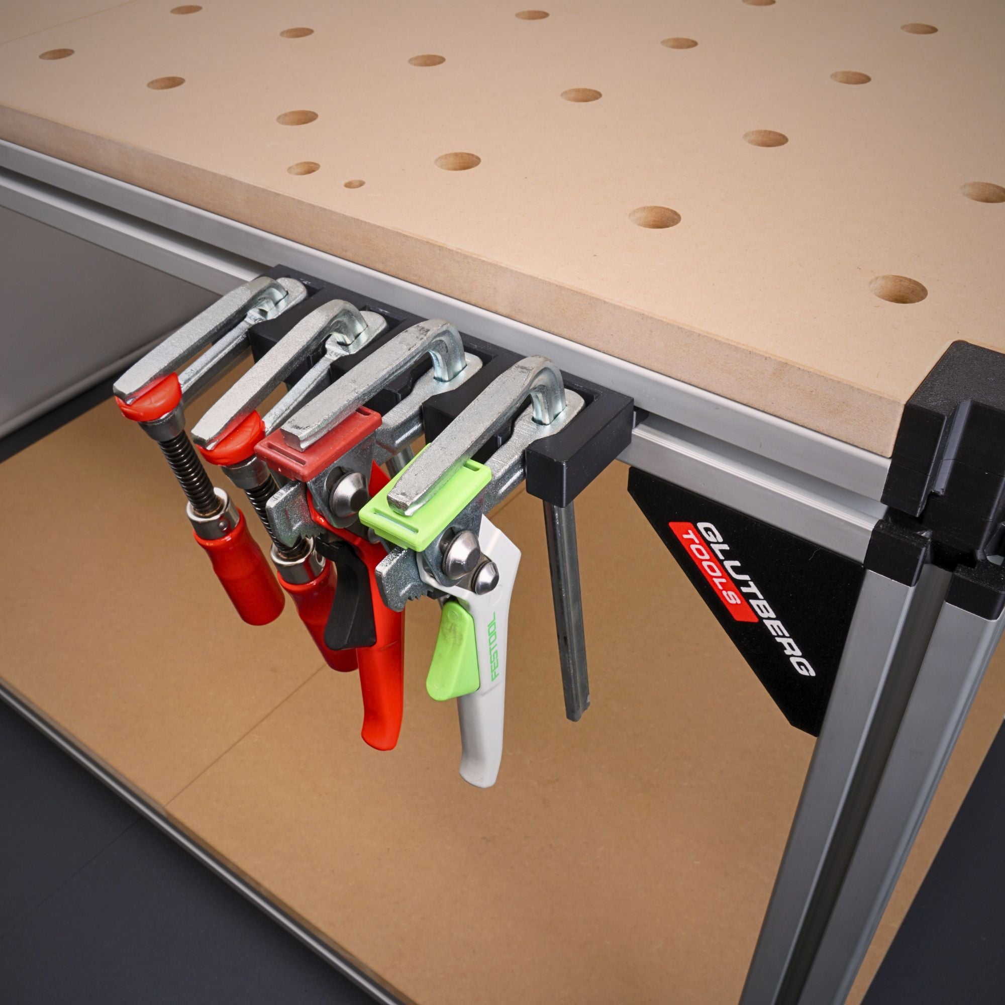 Zwingenhalter für die GLUTBERG Workstation Pro, bestückt mit mehreren Schraubzwingen und Hebelzwingen